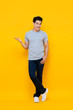 © Atstock Productions - Handsome young Asian man smiling and standing with open hand gesture