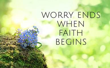 worry ends when faith begins - religion quote on nature background. blue flowers in forest