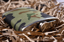 Men's Camouflage Flask On A Light Straw Background