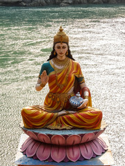 Rishikesh, India. Statue of sitting goddess Parvati on the riverbank of Ganga in Rishikesh.