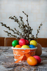  painted easter eggs in a basket and willow twigs