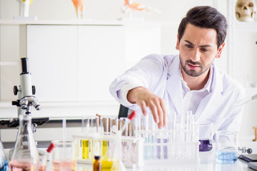 Wall Mural - attractive happiness scientist man lab technician assistant analyzing sample in test tube at laborat
