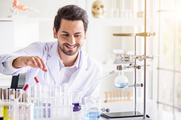Wall Mural - attractive happiness scientist man lab technician assistant analyzing sample in test tube at laborat