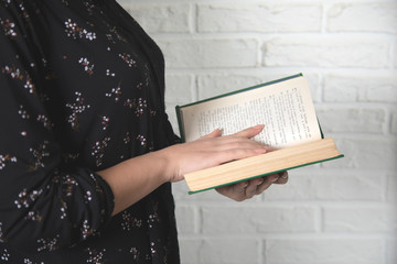 young woman hand holding green book