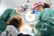 Professional dentist surgeon and assistant performing dental operation in a clinic with modern tools equipment