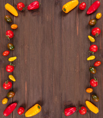  Bio Healthy food, cherry tomatoes and peppers on wooden background. Organic vegetables frame with copy space, top view