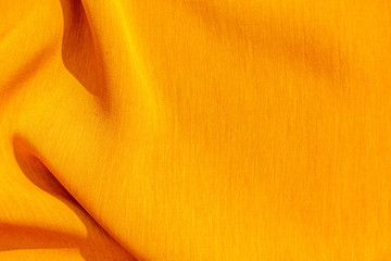 Smooth elegant yellow fabric silk or satin texture for background.