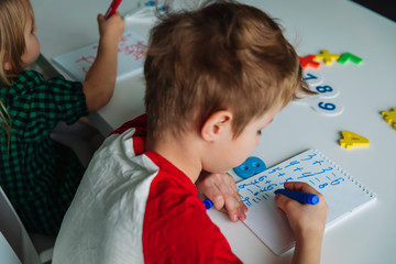 Wall Mural - boy and girl calculating numbers, kids doing homework