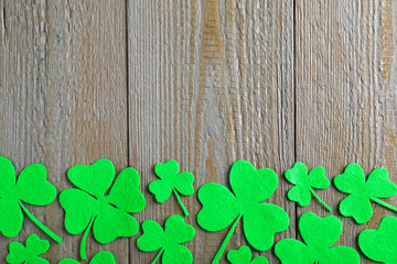 Flat lay composition with clover leaves on wooden table, space for text. St. Patrick's Day celebration