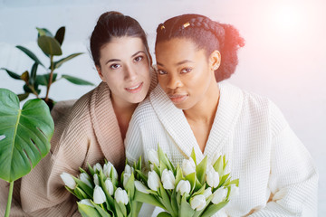 Wall Mural - young pretty asian, caucasian, afro woman posing cheerful together on brown background, lifestyle diverse nationality people concept