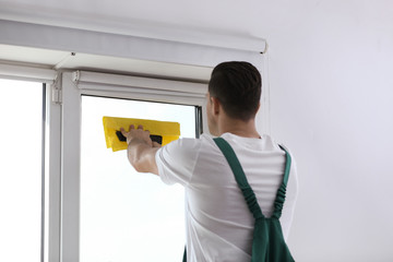 Poster - Professional worker tinting window with foil indoors