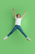 Crazy happy in jump. Caucasian young woman's portrait isolated on green studio background. Beautiful female model in white shirt. Concept of human emotions, facial expression, sales, ad, youth.