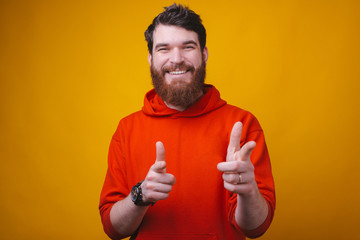 Wall Mural - Hey you look at this, cheerful bearded man pointing at the camera