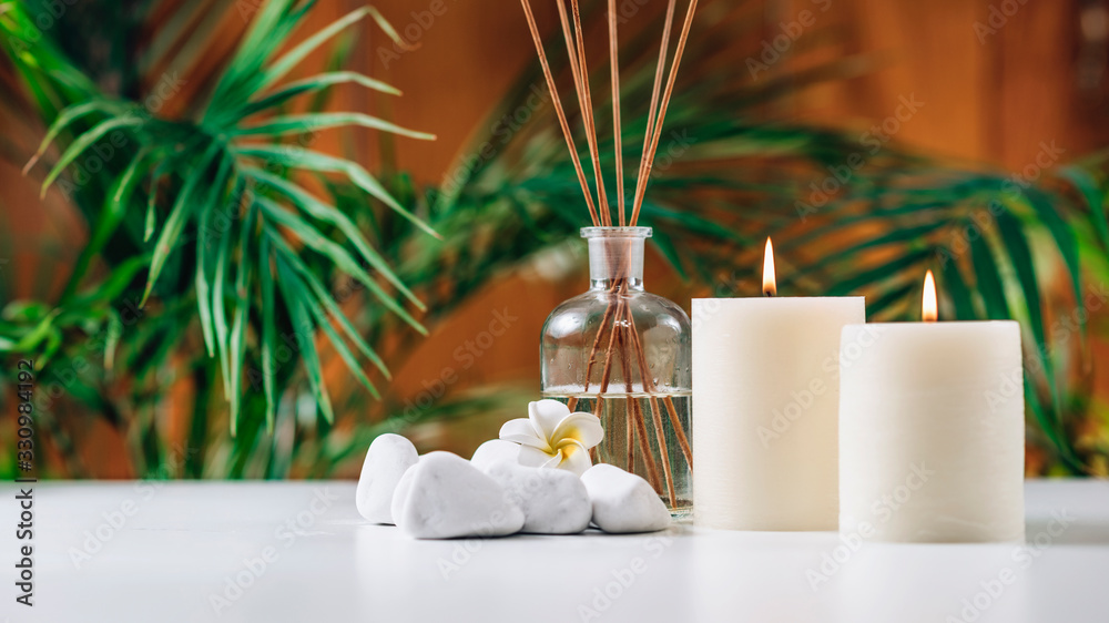 Aromatherapy Concept. Aromatic White Candles and Essential Oil Reed Diffusers - obrazy, fototapety, plakaty 