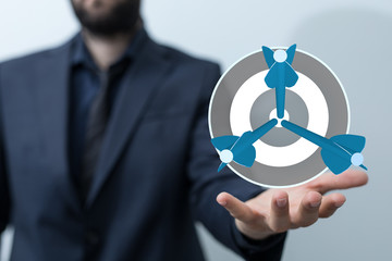 Aufkleber - hand holding a target with darts hitting the center over white background. Concept of .