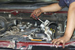 Image of a mechanic checking and fixing the engine