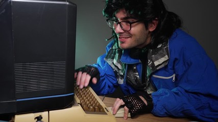 Excited computer geek using his old device and getting excited from what he is seeing. Using old technology in the 70s 80s 90s concept.