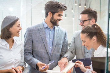 Wall Mural - Young business people discussing documents during at office meeting