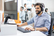 © Bojan - Smiling friendly helpline technical support agent with hands-free headset at call centre.