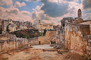 Wall Mural - Gravina in Puglia, Bari, Italy: landscape at sunrise of the old town seen from the entrance of the ancient aqueduct bridge