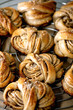 Traditional Swedish cardamom sweet buns Kanelbulle on cooling rack on beige linen table cloth. Close up
