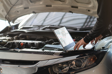 Wall Mural - Professional mechanic man using laptop computer to solve troubleshooting problem of the car