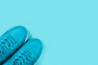 © Anna - Bright blue sneakers on pastel blue background. Concept of woman sport and healthy lifestyle in monochrome. Place for text, flat lay, top view.