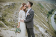 © sergiubirca - Smiling bride and groom spending time together. Posing on the mountain hills background. Dressed in white dress beautiful blonde caucasian bride and handsome groom. Hugs, kissess and enjoy the company