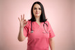 © Cipri Suciu  - Beautiful woman doctor with stethoscope, wearing pink scrubs showing OK sign
