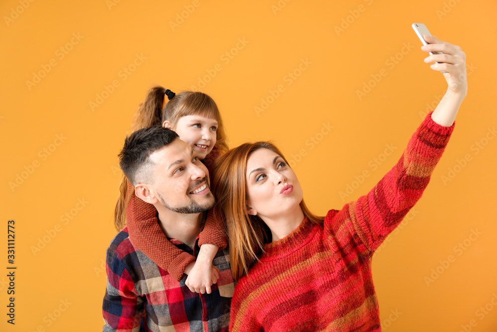Family taking selfie on color background
