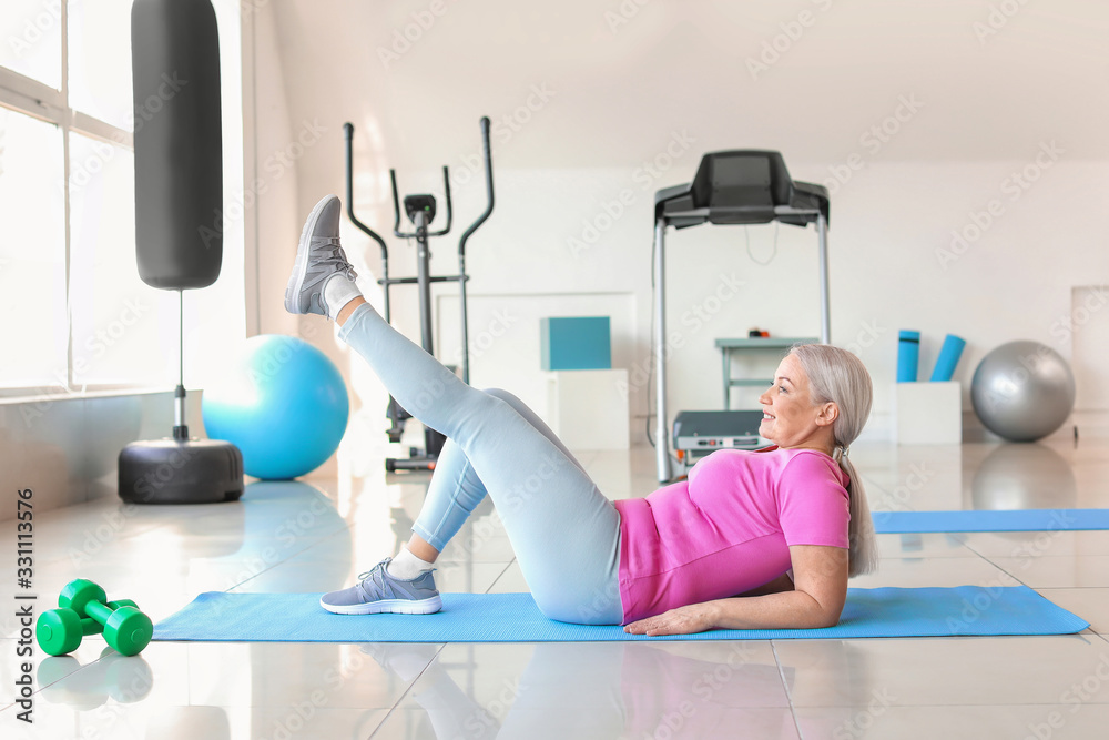 Sporty mature woman training in gym