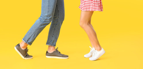 Legs of dancing young couple on color background