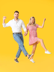 Poster - Happy dancing young couple on color background