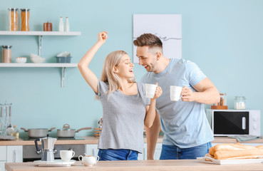 Wall Mural - Happy dancing young couple in kitchen