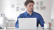 © stockbakers - Casual Adult Man Drinking Coffee while Working on Laptop