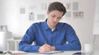 © stockbakers - Casual Adult Man Writing in Office