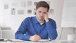 © stockbakers - Casual Adult Man Writing at Work