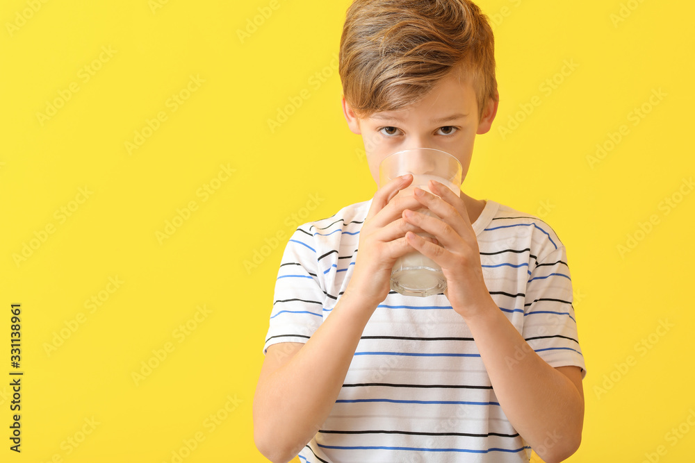 Little boy with milk on color background