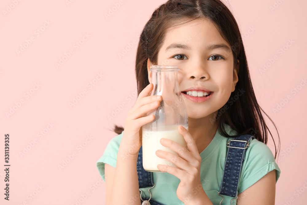 Cute Asian girl with milk on color background