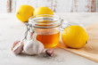 Alternative medicine, natural home remedy for cold and flu. Glass jar with honey, lemon and garlic