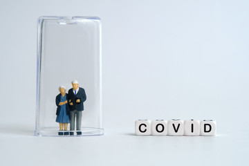 Pandemic corona virus conceptual miniature people photography – word beads alphabet isolation / quarantine concept with doctor and old / middle-aged figure on tube