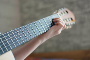 woman's hands playing acoustic guitar, close up