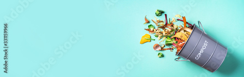 Fotografía Peeled vegetables in white compost bin on blue background