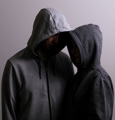 Man and woman hooded hugging, low key