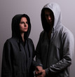 © Arsentyev Vladimir - Man and woman hooded hold hands, low key