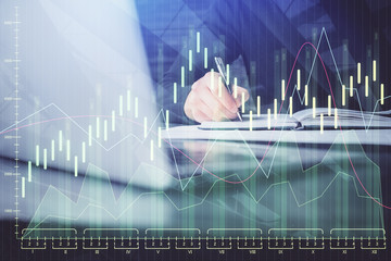 Double exposure of businessman with laptop and stock market forex chart.