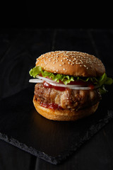 Wall Mural - tasty burger on wooden surface isolated on black