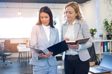 Business women in elegant formalwear planning business strategy at office