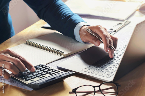 Fotomural businessman working on desk with using calculator and computer in office