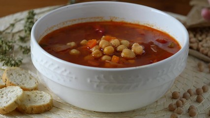 Wall Mural - Healthy eating, serving chickpeas soup with tomatoes in a bowl. Put on the table a bowl of creamy and rustic legume soup. Eating healthy vegetarian dinner. Cozy and warm food. Protein dinner.